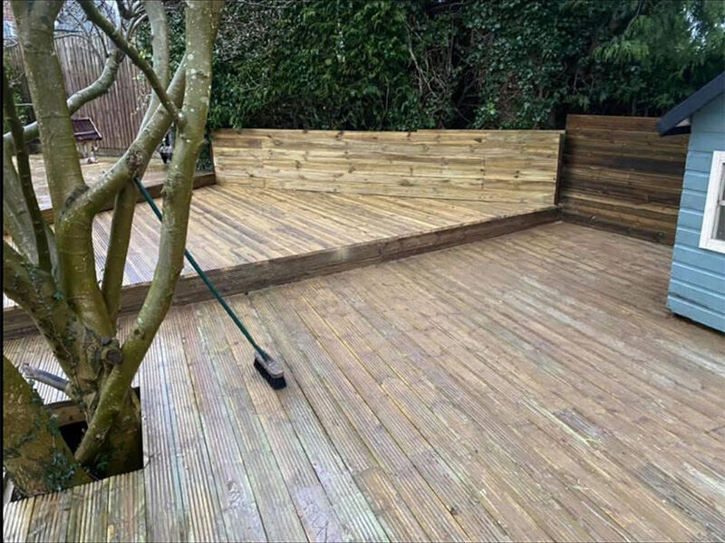 Large softwood deck along a garden fence