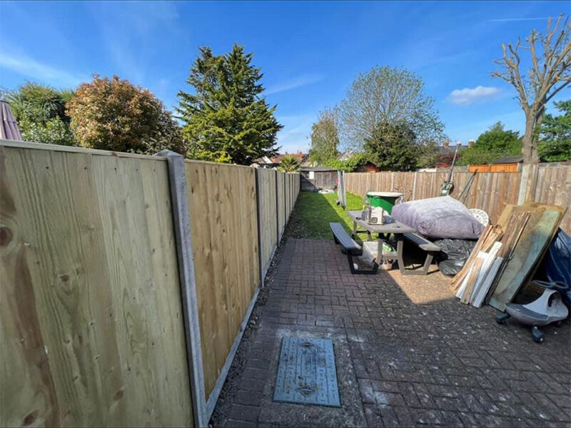 Closeboard fencing beside a block paved path