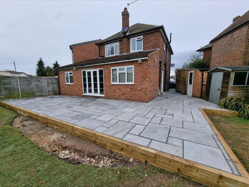 Large grey patio behind a family home